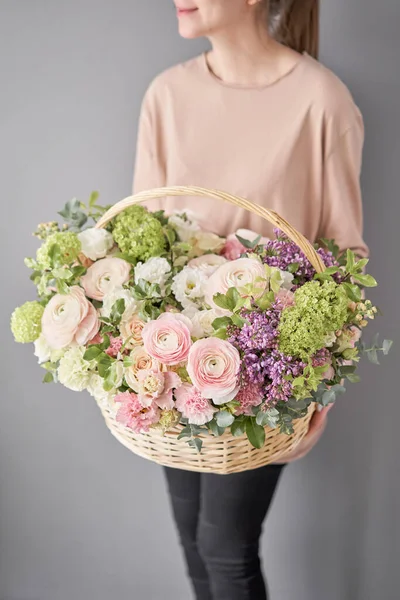 Livraison de fleurs. Arrangement de fleurs dans un grand panier en osier. Beau bouquet de fleurs mixtes à la main de la femme. Concept de boutique florale. Beau bouquet frais . — Photo