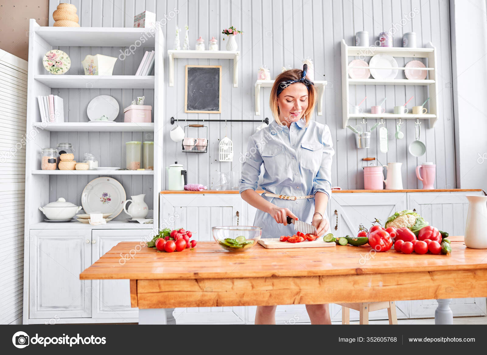 Hermosa joven está preparando ensalada de verduras en la ...