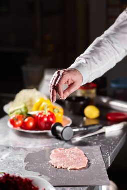 Şef domuz pirzolası ve terbiye eder. Restoran mutfağında profesyonel bir aşçı..