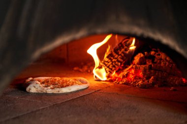 Napoli restoranında geleneksel ahşap fırında margherita pizza pişirdim. Orijinal Napoli pizzası. Kırmızı sıcak kömür.