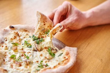 Erkekler Gorgonzola ve armutla lezzetli pizza yerler. İtalya 'daki Napoli restoranında geleneksel ahşap fırında pişirilmiş. Orijinal Napoli pizzası. Kırmızı sıcak kömür.