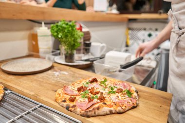 Napoli usulü jambonlu pizza. Jambonlu pizza ve ahşap masada sosis. Mutfak