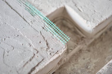 Tamamlanmış zemin, yeşil ağla güçlendirilmiş. Kötü bir zemindeki çatlakların tamiri. bitirmeden yeni bina