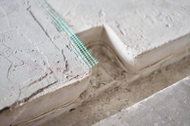 Tamamlanmış zemin, yeşil ağla güçlendirilmiş. Kötü bir zemindeki çatlakların tamiri. bitirmeden yeni bina