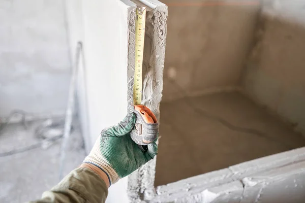 건축 인부들은 계량 테이프 로 계량 판을 측정 한다. 내부 벽의 건설에는 홈 모양의 산등성 이 있는 석고 콘크리트 판을 사용 한다. 혀 - 그루브 석고 블록 — 스톡 사진