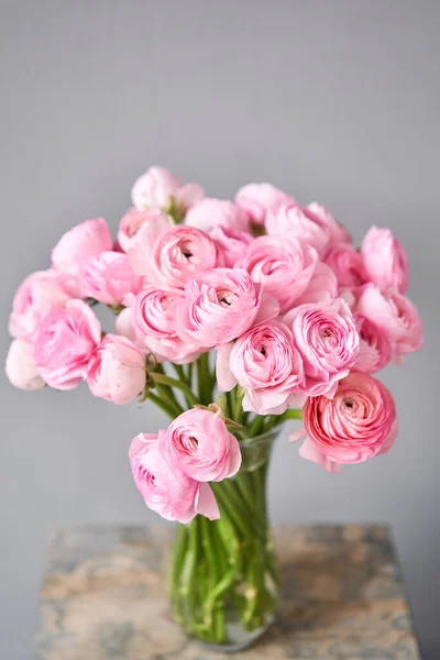 Весенний фон, цветы обои. Персидский лютик. Букет розовых цветков раннункула на светло-голубом фоне. Ваза на винтажном деревянном столе. Обои — стоковое фото