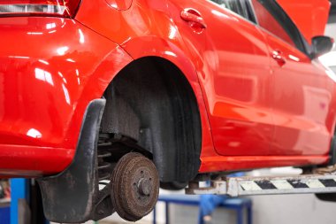 Paslı davul frenleri, kırmızı arabanın arkası. Garajdaki eski fren diskini yenisiyle değiştir. Otomatik tamirci onarımı