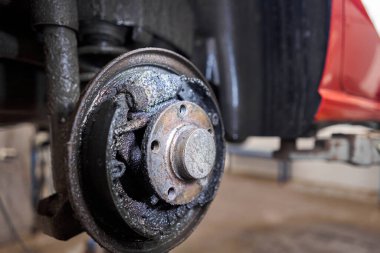 Paslı davul frenleri, kırmızı arabanın arkası. Garajdaki eski fren diskini yenisiyle değiştir. Otomatik tamirci onarımı