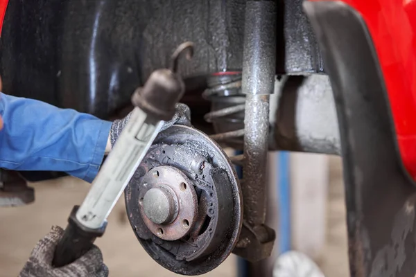 Frenos de tambor oxidados, atrás en el coche rojo. Cambiar el disco de freno viejo a nuevo en el coche en un garaje. Auto mecánico de reparación — Foto de Stock