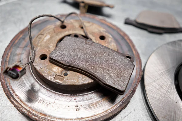 Old used and new to change for safety car brake disc and pad on metal table of an auto mechanic. Auto repair concept. — Stock Photo, Image