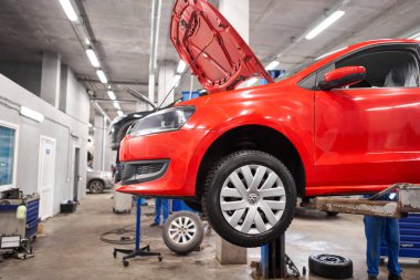 Rusya, Nizhny Novgorod - 13 Mart 2020: en iyi otomobil hizmeti. Tamirci arabanın frenlerini değiştiriyor. Paslı davul frenleri, kırmızı arabanın arkası. Garajdaki eski fren diskini yenisiyle değiştir..