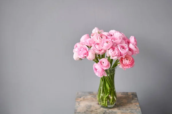 Våren bakgrund, blomma Bakgrund. Persisk smörblomma. Bunch rosa ranunculus blommor på ljusgrå bakgrund. Vas på vintage träbord. Bakgrund — Stockfoto