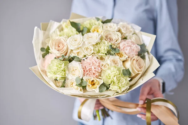 Negozio floreale europeo. Bellissimo bouquet di fiori misti nelle mani della donna. Lavoro del fioraio a un negozio di fiori. Consegna fresco fiore reciso . — Foto Stock