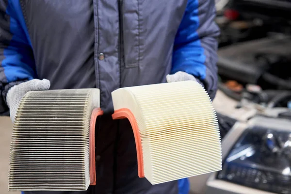 Nový a starý špinavý automobilový vzduchový filtr v rukou automechanika. Koncept automatických oprav. — Stock fotografie