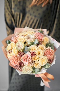 Avrupa çiçekçisi. Kadın ellerinde güzel bir buket karışık çiçek. Çiçekçide çiçekçinin işi. Taze kesilmiş çiçek getirdim..