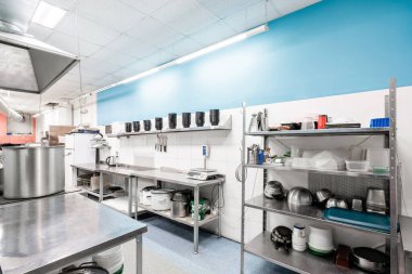 Profesyonel mutfakta yüzey ve mutfak ekipmanları var. Hazırlık masaları, tavalar, tencereler, ocaklar ile yemek pişirme.