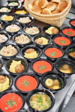 Yemek servisi. Plastik tek kullanımlık beslenme çantasında sağlıklı doğal gıdalar var. Tavuk çorbası, çorba püresi, pirzola, deniz ürünleri makarnası, salata, taze çörekle pilav..