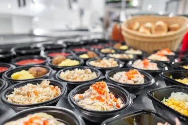 Bir sıra plastik tek kullanımlık beslenme çantası ve sağlıklı doğal yiyecekler. Çorbalar, kremalı çorba, garnitürlü ana yemek, salatalar. Yemek servisi. Ofiste öğle yemeği..