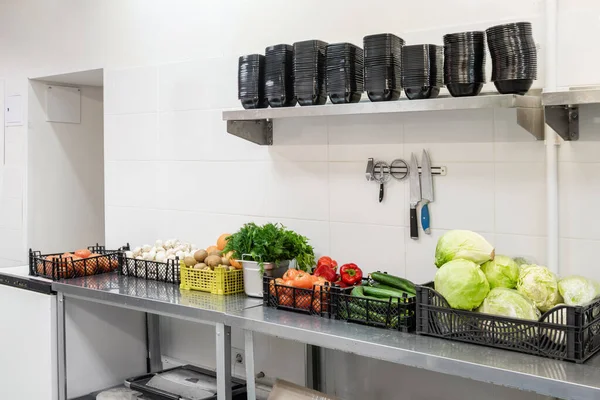 Verduras frescas y coloridas y frutas en la cocina en acero plateado. Superficie de trabajo y equipo de cocina en cocina profesional. Cocinar con mesas de preparación, sartenes, ollas, estufas . —  Fotos de Stock