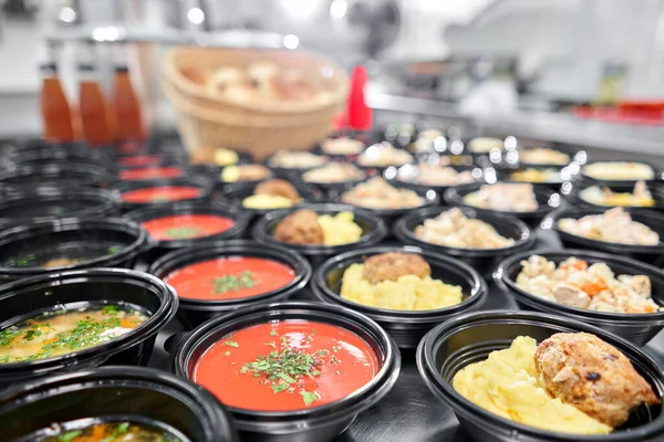 Fila de plástico desechable lonchera con alimentos naturales saludables. Sopas, sopa de crema, plato principal con guarnición, ensaladas. Entrega de comida. Almuerzo en la oficina . — Foto de Stock