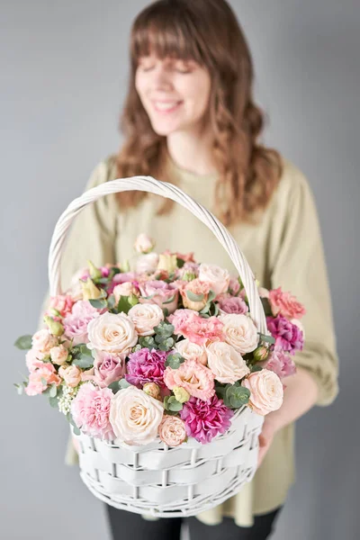 Pequeña floristería y entrega de flores. Arreglo floral en canasta de mimbre. Hermoso ramo de flores mixtas en mano de mujer. Hermoso ramo fresco. — Foto de Stock