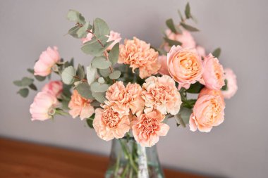 Tahta masadaki cam vazoda çiçekler. Dekorasyon için taze kesilmiş çiçekler. Teslimat çiçeği..