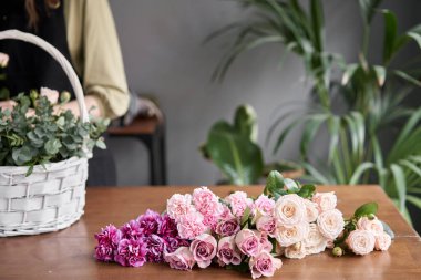 Çiçek dükkanı konsepti. Hasır bir sepette çiçek aranjmanı için boşluk. Güzel bir buket karışık çiçek. Yakışıklılar. Çiçek teslimatı.