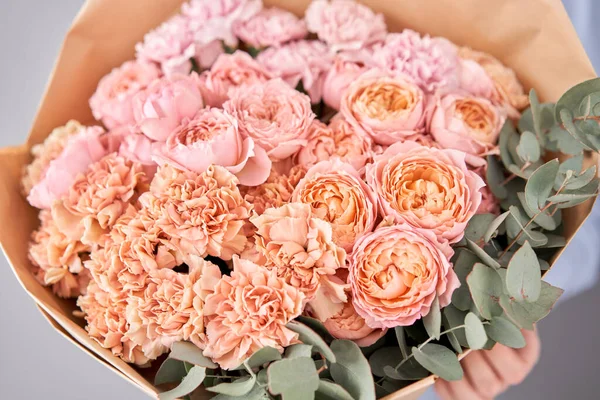 Flores puestas en manos de mujeres. Flores recién cortadas para la decoración del hogar. Tienda floral europea. Hermoso ramo de flores mixtas. Entrega flor fresca cortada . — Foto de Stock