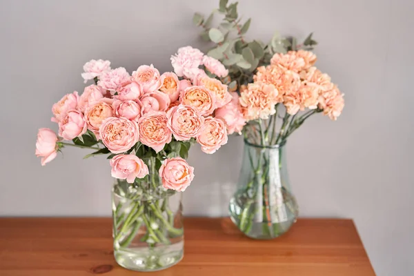 Цветы в стеклянной вазе на деревянном столе. Свежие срезанные цветы для украшения дома. Цветок доставки . — стоковое фото