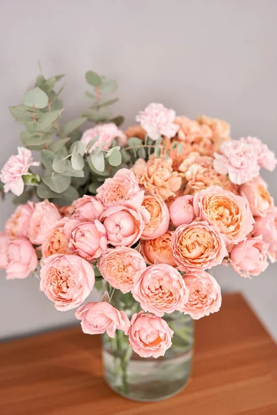 Flores en jarrón de cristal sobre mesa de madera. Flores recién cortadas para la decoración del hogar. Entrega flor . —  Fotos de Stock