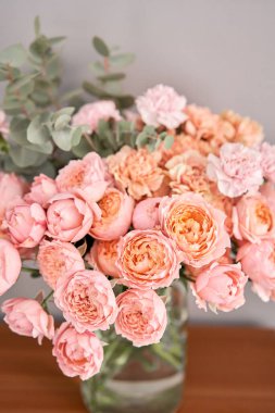 Tahta masadaki cam vazoda çiçekler. Dekorasyon için taze kesilmiş çiçekler. Teslimat çiçeği..
