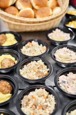 Yemek servisi. Plastik tek kullanımlık beslenme çantasında sağlıklı doğal gıdalar var. Tavuk çorbası, çorba püresi, pirzola, deniz ürünleri makarnası, salata, taze çörekle pilav..