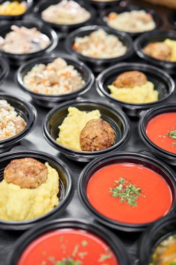 Yemek servisi. Plastik tek kullanımlık beslenme çantasında sağlıklı doğal gıdalar var. Tavuk çorbası, çorba püresi, pirzola, deniz ürünleri makarnası, salata, taze çörekle pilav..