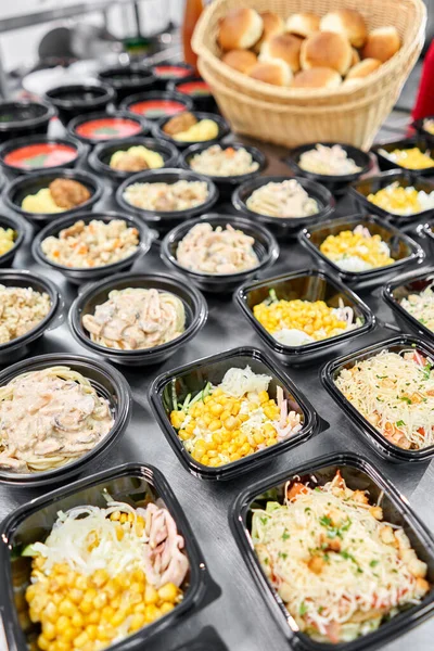 Food delivery. Different in plastic disposable lunch box with healthy natural food. Chicken broth, mashed soup, mashed potatoes with cutlet, seafood pasta, salads, pilaf with a fresh bun. — Stock Photo, Image