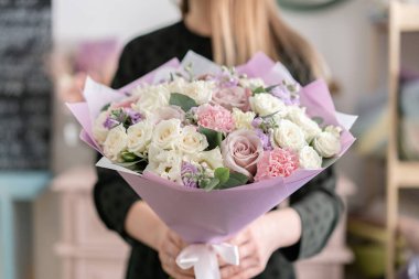 Kadınların elinde güzel bir buket. Çiçekçi dükkanındaki çiçekçinin işi. Taze kesilmiş çiçek getirdim. Avrupa Çiçek Dükkanı.