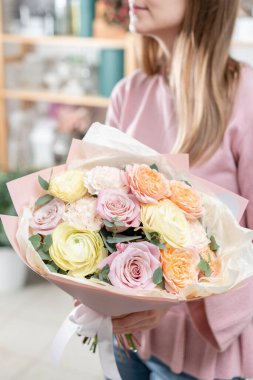 Kadınların elinde güzel bir buket. Çiçekçi dükkanındaki çiçekçinin işi. Taze kesilmiş çiçek getirdim. Avrupa Çiçek Dükkanı.