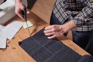 Kapalı Terzi yün kesim kumaşı. Çizgi deseni. El sanatları ustası yün kumaştan papyonlar için dikdörtgen boşluklar yapıyor. Tekstil atölyesinde dikiş makinesiyle çalışıyorum..