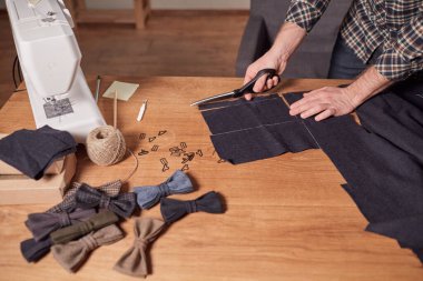 Kapalı Terzi yün kesim kumaşı. Çizgi deseni. El sanatları ustası yün kumaştan papyonlar için dikdörtgen boşluklar yapıyor. Tekstil atölyesinde dikiş makinesiyle çalışıyorum..