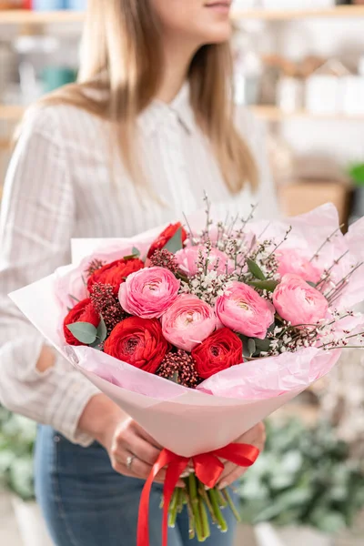 Hermoso ramo de flores mixtas en manos de mujeres. el trabajo de la floristería en una florería. Bonito ramo fresco. Entrega de flores — Foto de Stock