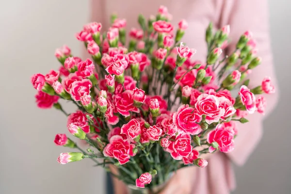 Bloemen van roze spray anjer in de hand van de vrouw. Ongebruikelijke bloemen dianthus. Voorjaarsbloemenpatroon — Stockfoto