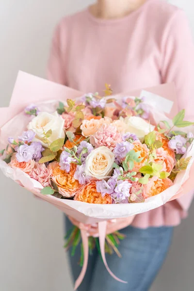 Bellissimo bouquet di fiori misti nelle mani delle donne. il lavoro del fioraio in un negozio di fiori. Bel bouquet fresco. Consegna fiori — Foto Stock