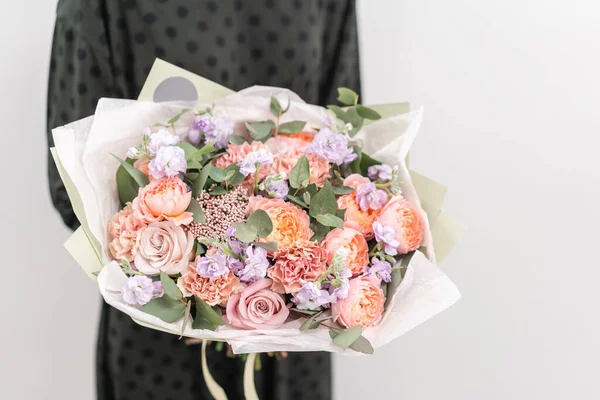 Hermoso ramo de flores mixtas en manos de mujeres. el trabajo de la floristería en una florería. Bonito ramo fresco. Entrega de flores —  Fotos de Stock