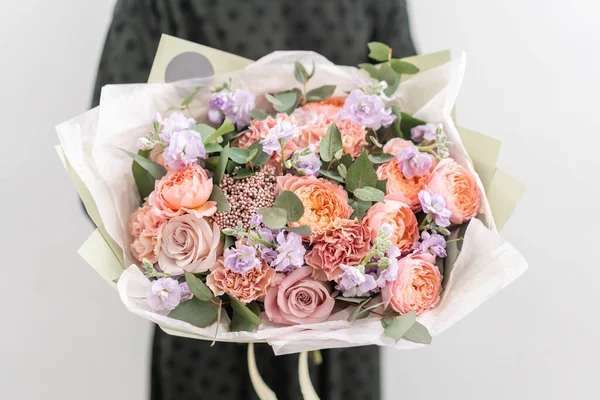 Beautiful bouquet of mixed flowers in womans hands. the work of the florist at a flower shop. Handsome fresh bouquet. Flowers delivery — Stock Photo, Image