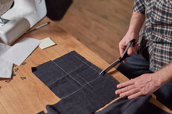 Zbliżenie Krawiec cięcia wełny tkaniny. wzór linii. Rzemieślnik robi prostokątne blanki do krawatów z wełnianej tkaniny. Praca z maszyną do szycia w pracowni włókienniczej. — Zdjęcie stockowe
