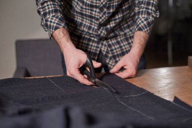 Kapalı Terzi yün kesim kumaşı. Çizgi deseni. El sanatları ustası yün kumaştan papyonlar için dikdörtgen boşluklar yapıyor. Tekstil atölyesinde dikiş makinesiyle çalışıyorum..