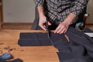 Kapalı Terzi yün kesim kumaşı. Çizgi deseni. El sanatları ustası yün kumaştan papyonlar için dikdörtgen boşluklar yapıyor. Tekstil atölyesinde dikiş makinesiyle çalışıyorum..