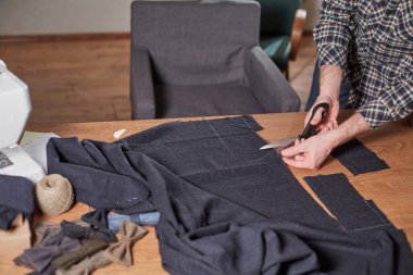 Kapalı Terzi yün kesim kumaşı. Çizgi deseni. El sanatları ustası yün kumaştan papyonlar için dikdörtgen boşluklar yapıyor. Tekstil atölyesinde dikiş makinesiyle çalışıyorum..