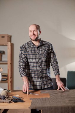 Terzi yün kesim kumaşı. Çizgi deseni. El sanatları ustası yün kumaştan papyonlar için dikdörtgen boşluklar yapıyor. Tekstil atölyesinde dikiş makinesiyle çalışıyorum..