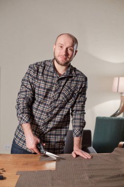 Terzi yün kesim kumaşı. Çizgi deseni. El sanatları ustası yün kumaştan papyonlar için dikdörtgen boşluklar yapıyor. Tekstil atölyesinde dikiş makinesiyle çalışıyorum..