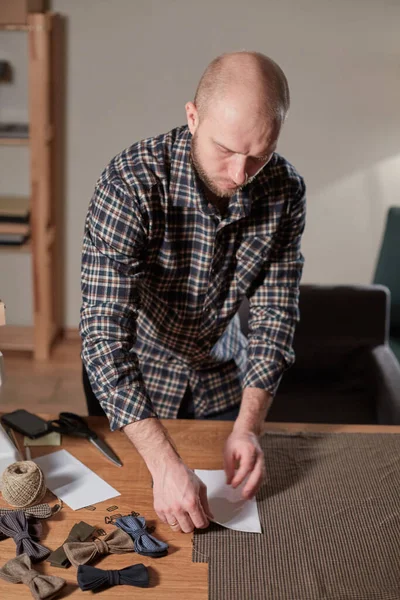 Skräddarsytt ulltyg. linjemönstret. Hantverkare Gör rektangulära ämnen för Bow slipsar av ull tyg. Arbeta med symaskin i en textilstudio. — Stockfoto